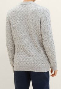 Pull gris clair en point de câble avec un col rond, un motif texturé, des poignets et un ourlet côtelés, réalisé en mélange de laine de poids moyen.