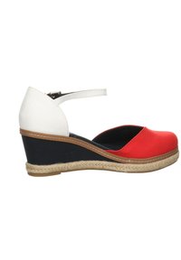 Zapato de cuña con parte superior de tela roja y blanca, media suela negra y detalles de yute trenzado. Cuenta con una correa en el tobillo para un ajuste seguro.