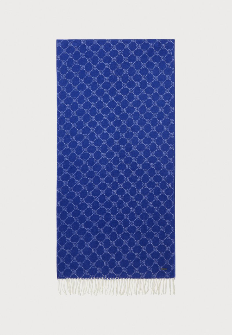 Coperta blu con un motivo geometrico, bordi frangiati, texture tessile soffice e accenti azzurri a contrasto.