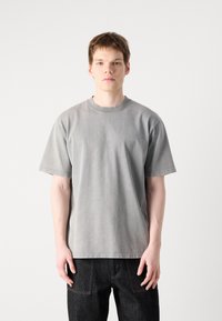 Gray short-sleeve t-shirt in a relaxed fit, made of soft cotton, featuring a crew neckline and subtle textured finish.