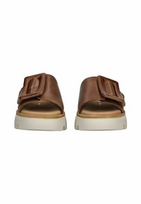 Sandales à glissière en cuir marron avec une large sangle et une grande boucle, présentant une semelle beige rembourrée. Texture lisse et design minimal.