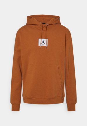 Brauner Pullover-Hoodie mit vorderer Kängurutasche, verstellbarer Kapuzenkordel und kleinem schwarzem Jumpman-Logo auf weißem Patch in der Brustmitte.