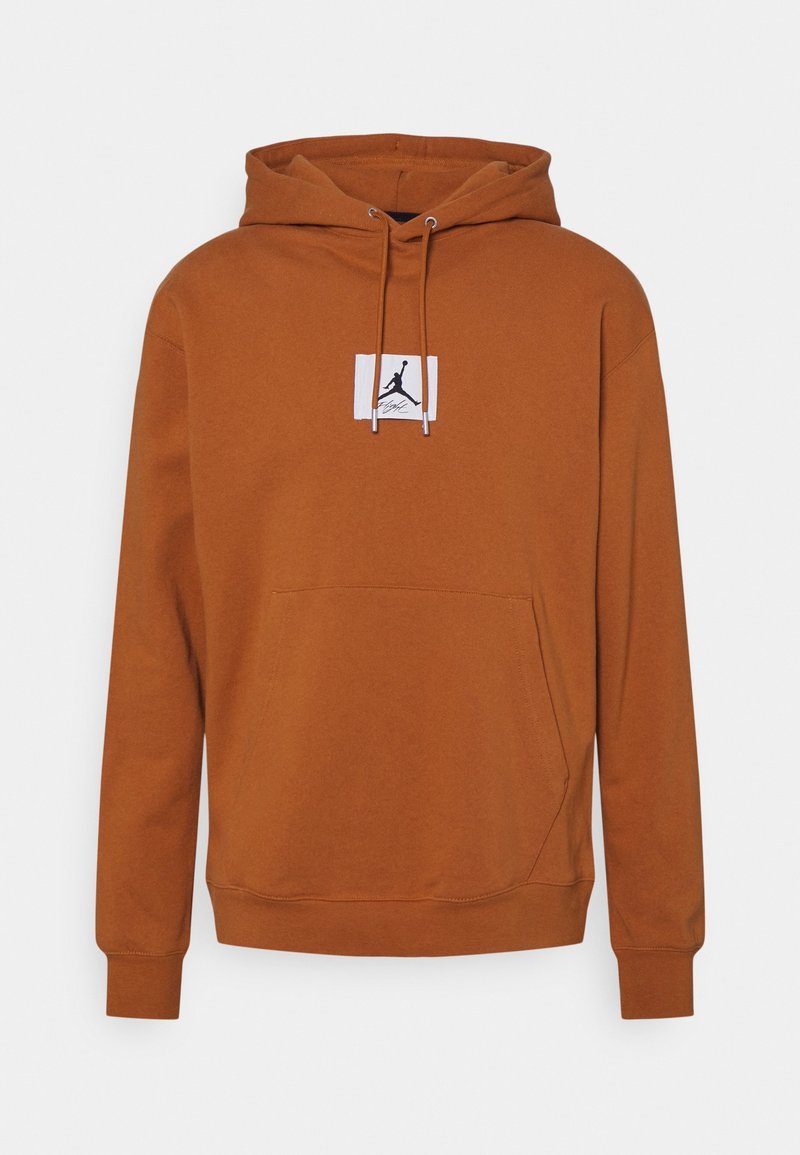 Sweat à capuche marron avec poche kangourou devant, capuche avec cordon ajustable et petit logo Jumpman noir sur un patch blanc au centre de la poitrine.
