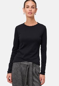 Zwarte blouse met lange mouwen en een scalloped halslijn, slim fit ontwerp en een gladde textuur, gecombineerd met gestreepte broek.