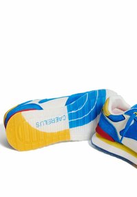 Niebieskie i białe trampki o teksturowanej powierzchni, z żółtym i czerwonym akcentem, podeszwą EVA oraz charakterystycznym logo na pięcie.