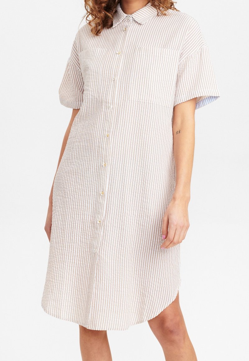 Gestreiftes Button-Down-Kleid in Beige und Weiß, mit kurzen Ärmeln, einem Kragen, zwei Brusttaschen und einem abgerundeten Saum. Strukturierter Stoff.