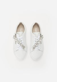 Hvide lædersneakers med rund tæer, snørebåndslukning og dekorative sølvdetaljer på siderne. Gummisåler.