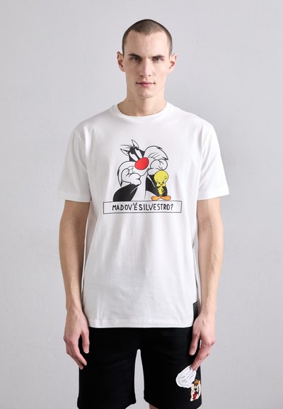 T-shirt en coton blanc avec un imprimé graphique de Sylvester et Tweety, avec une touche de rouge sur le nez de Sylvester. Le texte en dessous dit "MADOV'È SILVESTRO?"