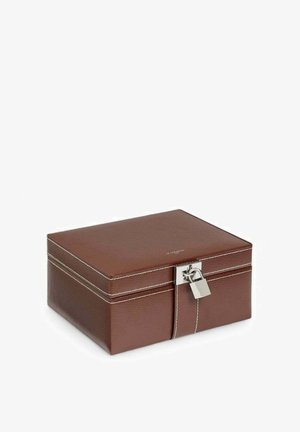 Boîte de rangement en cuir marron avec surface texturée, serrure argentée et couture blanche. Forme carrée, dessus lisse et design robuste.