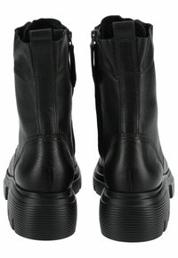 Botas de tobillo de cuero negro con una superficie texturizada, que presentan una suela gruesa con estrías y un cierre de cremallera lateral para facilitar su uso.