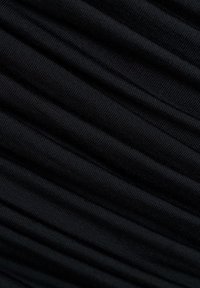 Mustast soonikkoega kangas, millel on diagonaalsed voltid, mis loovad tekstuurse mustri ja pehmed varjud.