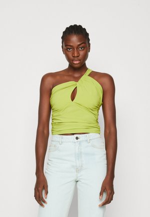 Haut vert ajusté avec un design noué et une découpure en forme de trou de clé à l'avant, associé à un jean taille haute bleu clair. Texture lisse.