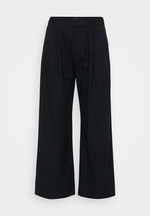 Juodos plačios kelnės, pagamintos iš minkštos medžiagos, su lygia priekiu, matomomis klostėmis ir juosmeniu su kilpomis diržui.