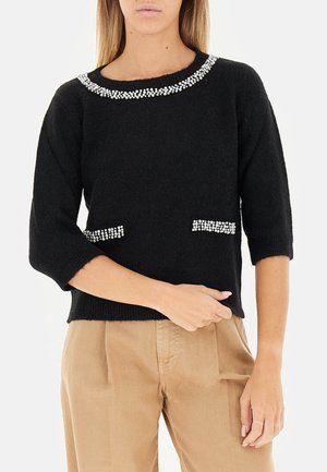 Maglione nero lavorato a maglia con scollatura arrotondata, maniche a tre quarti e decorazioni di gioielli sul colletto e sulle tasche. Tessuto morbido.