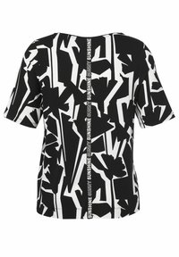 Schwarz-weißer kurzärmliger Oberteil mit einem abstrakten geometrischen Muster und vertikalem "SUNNY"-Text entlang der hinteren Naht. Weicher Stoff.