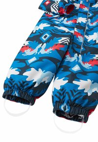 Kleurrijk kinderen sneeuwpak in blauw, met abstracte patronen in rood, wit en marineblauw. Elastische manchetten met lussen om over de laarzen te bevestigen.