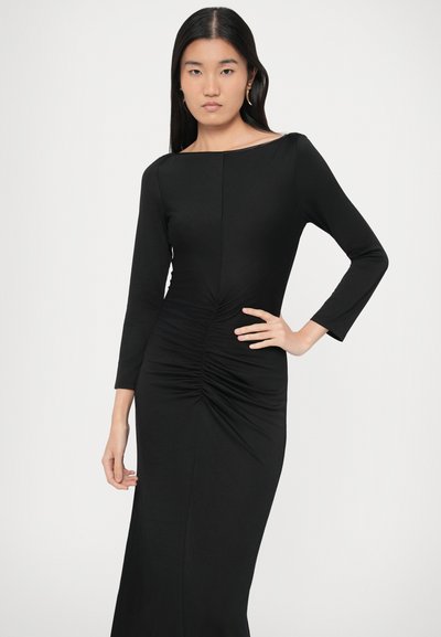 Czarna sukienka z długim rękawem i dekoltem w kształcie łódki, z marszczeniami w talii i dopasowanym krojem, wykonana z gładkiej tkaniny.