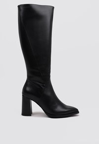 Botas de cuero negras hasta la rodilla con punta afilada y tacón cuadrado. Presentan una textura suave y detalles de costura diagonal.