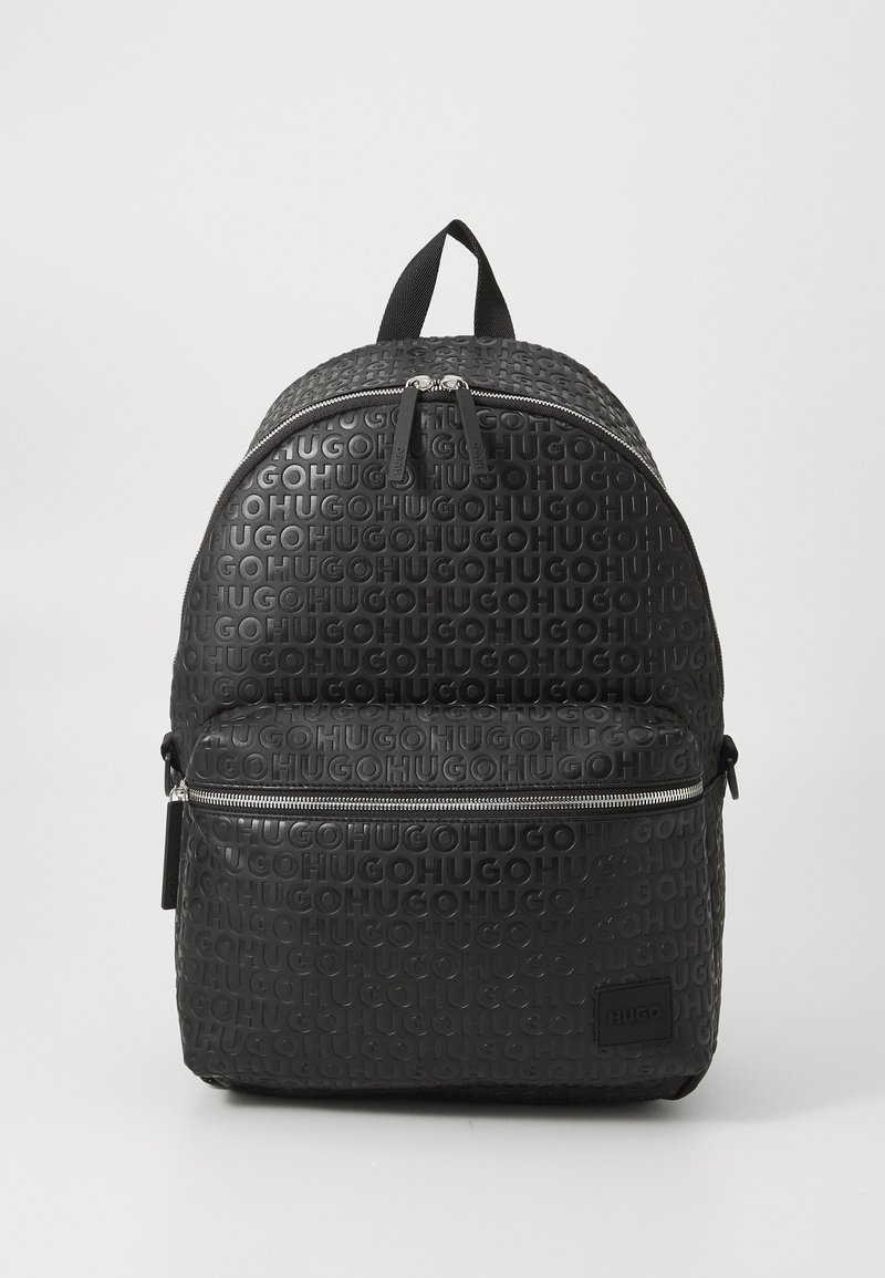Mochila negra con patrón de logotipo en relieve "HUGO", forma redondeada, textura suave, compartimentos con doble cremallera y un asa en la parte superior para llevar.