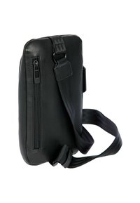 Sac à épaule en cuir noir avec une surface texturée, des poches zippées, une sangle réglable et une forme rectangulaire compacte.