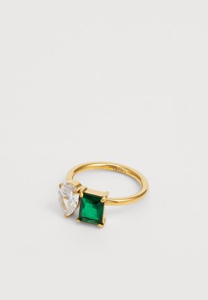 Anello in tono oro con una pietra trasparente a forma di pera e una pietra verde rettangolare, entrambe montate su ganci con una fascia liscia.