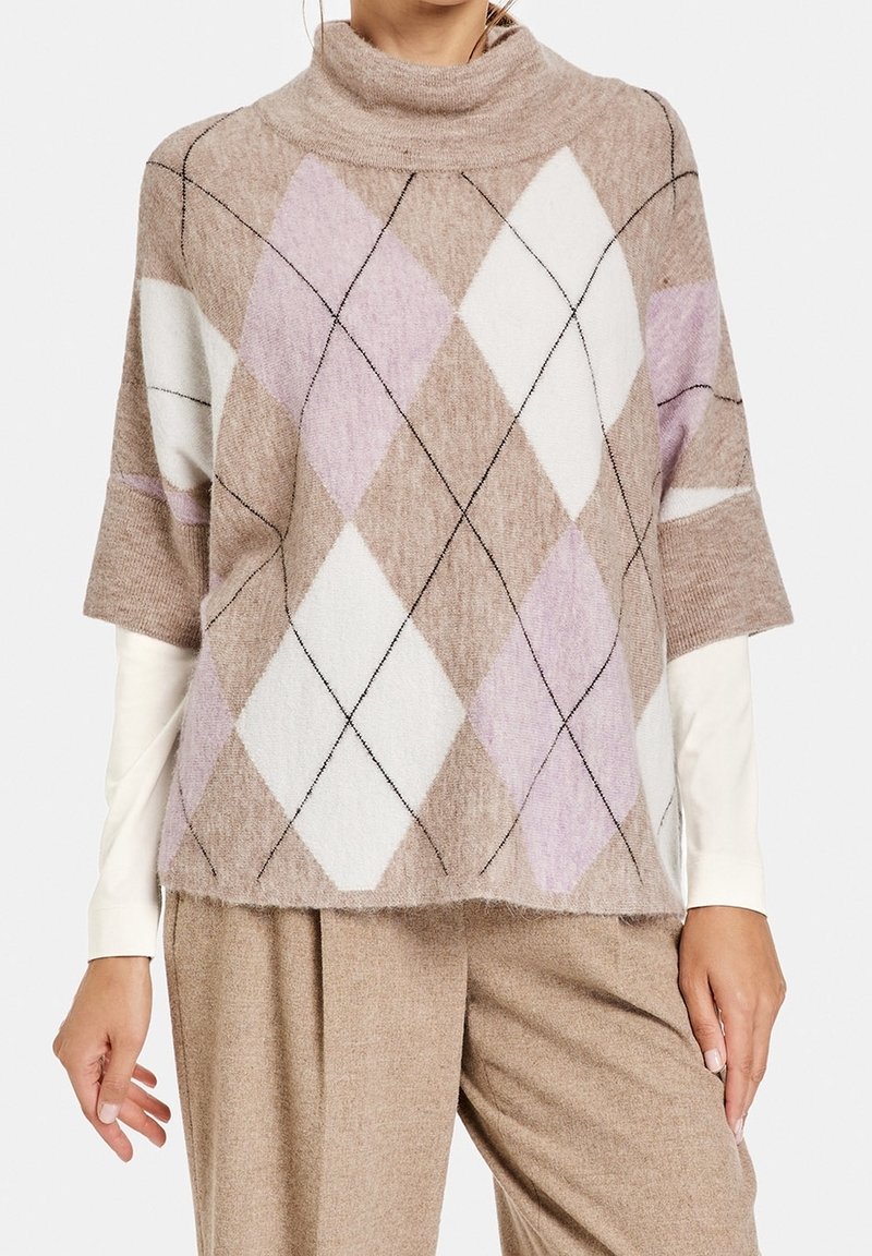 Maglione beige a collo alto a maniche corte con motivo a diamante in bianco, rosa pallido e marrone con contorni neri. Tessuto morbido e strutturato.