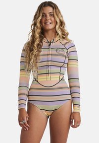 Costume da bagno a maniche lunghe con righe pastello di rosa, giallo, lavanda e verde. Presenta una zip frontale e una patch con logo sul petto.