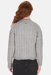 Pull en tricot gris avec un motif de câble texturé, présentant un col rond et un ourlet côtelé, vu de l'arrière.