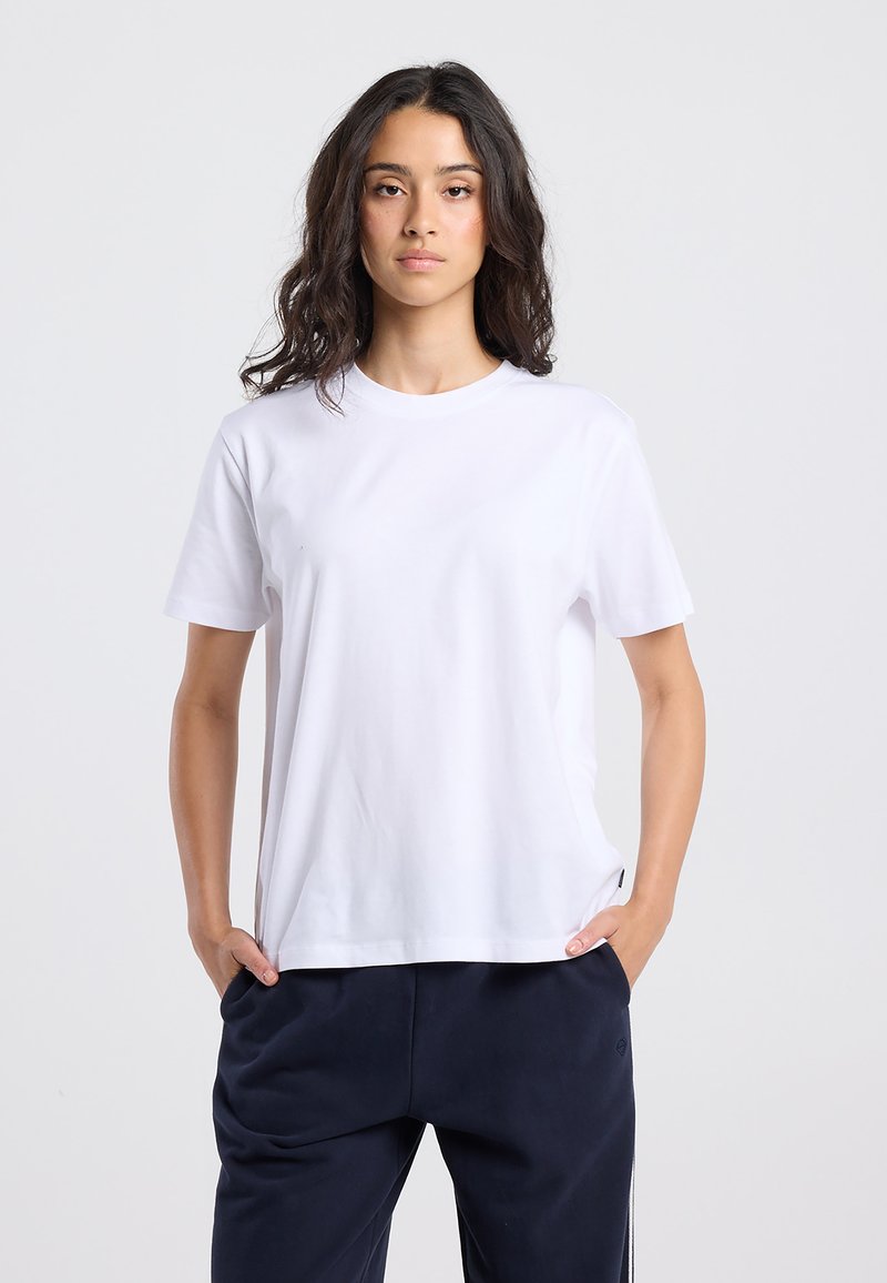 White cotton t-shirt with short sleeves, crew neck, and a relaxed fit. Smooth texture, minimal design, no visible patterns or accents.