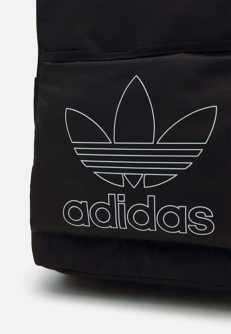 Schwarzer Rucksack mit einem weißen Adidas Trefoil-Logo und Text. Hergestellt aus strukturiertem Stoff, mit einer Reißverschlusstasche und robusten Nähten.