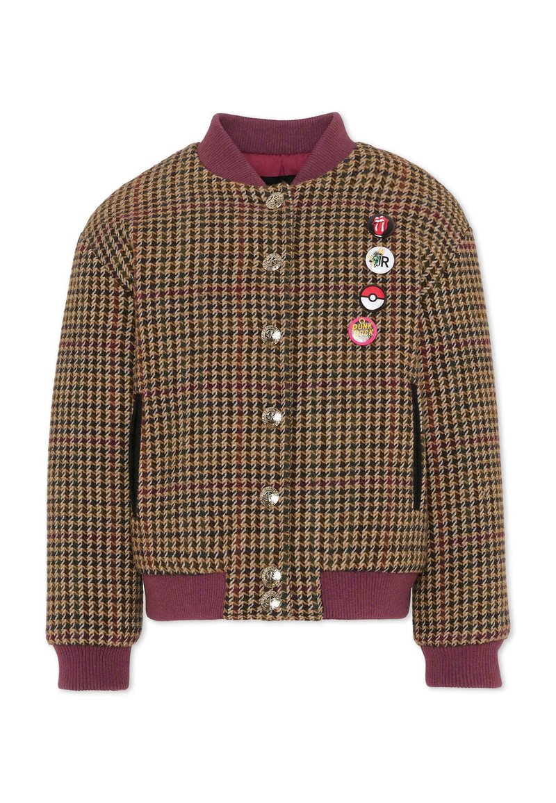 Marynarka w wzór hounds-tooth w kolorach brązowym, burgundowym i kremowym, z prążkowanym burgundowym kołnierzem i mankietami, posiadająca srebrne guziki i cztery kolorowe przypinki.