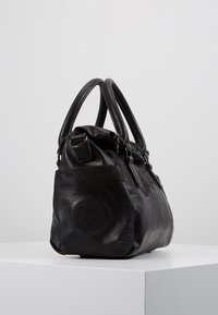 Sac à main en cuir noir avec surface texturée, forme courbée, double anse et motif floral en relief. Détails en métal argenté.