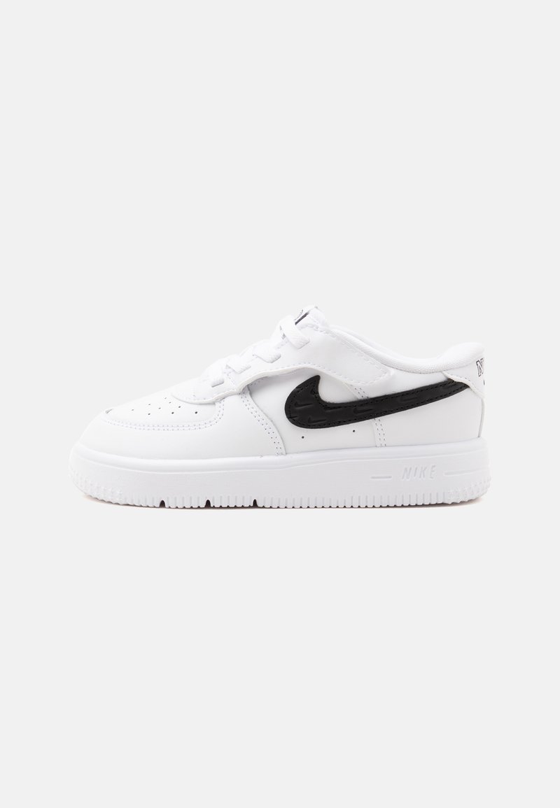 Λευκό αθλητικό παπούτσι Nike με μαύρο λογότυπο swoosh, σχέδιο με κορδόνια και παχιά σόλα σε απλό φωτεινό φόντο, πλαϊνή όψη.