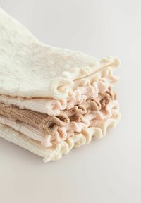 Stos teksturowanych ręczników w kremowym, jasnoróżowym i brązowym kolorze, z falbaniastymi brzegami oraz różnorodnymi jednolitymi i w paski wzorami. Miękka tkanina.