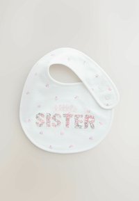 Bavetă albă din bumbac, cu text brodat „little SISTER” în modele florale, cu mici flori roz presărate pe material. Două închizători cu capse.