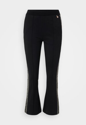 Juodos platėjančios kelnės su plačiu diržu, turinčios raštuotas šonines juostas. Pagamintos iš elastingos medžiagos, suteikiančios patogų prigludimą.