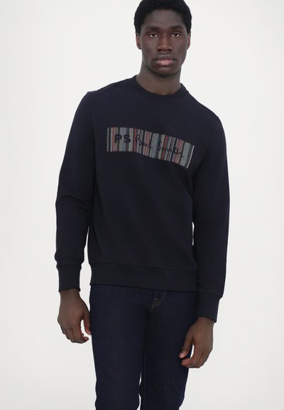 Sweatshirt marine avec un motif rayé horizontal texturé, des couleurs contrastées et des lettres brodées sur la poitrine.