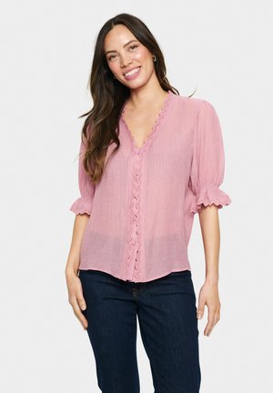 Helles pinkes Bluse mit V-Ausschnitt und gewelltem Saum, ausgestattet mit einer durchgehenden Knopfleiste und Puffärmeln mit Rüschendetails.