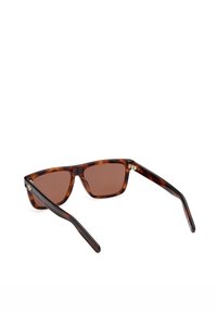 Lunettes de soleil rectangulaires teintées marron avec montures en écaille de tortue et détail logo doré sur les branches, présentées sur un fond blanc.