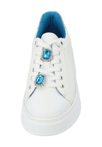 White sneaker with rounded toe, embellished with two blue gem-like accents. Features a blue inner lining and white laces. Smooth material.