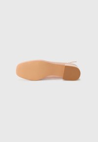 Nude high-heeled shoe with a smooth, glossy patent finish and a tapered toe, featuring a rubber sole with texture for grip.