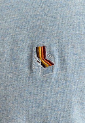 Light blue fabric featuring a textured pattern, with a small embroidered chair design in red, orange, and yellow stripes.