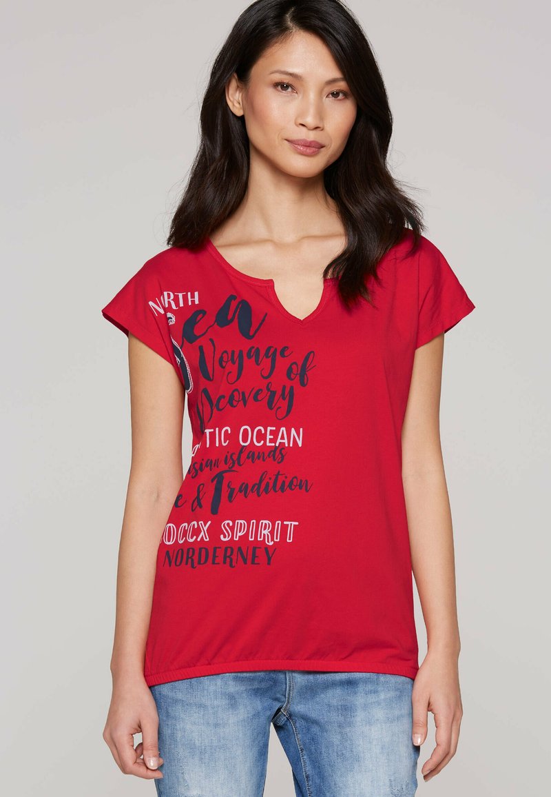 Red cotton t-shirt featuring a V-neck, short sleeves, and graphic text in black. Casual fit with a slightly loose design and round hem.