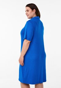Abito camicia blu a costine con maniche corte e colletto, caratterizzato da una silhouette dritta e una texture liscia, che arriva fino a metà polpaccio.