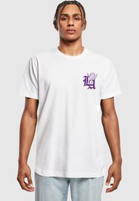 White cotton t-shirt with short sleeves, featuring a purple graphic design on the left chest, showcasing a stylized "LA" and wings.