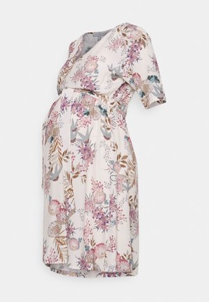 Robe de maternité en tissu rose clair avec motifs floraux violets et verts. Manches courtes, modèle portefeuille et taille élastique pour plus de confort.