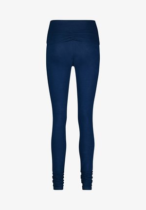 Laivastonsiniset legginsit, joissa on tiukka muotoilu, leveä, ryppyreunainen vyötärö ja rypytetyt nilkkayksityiskohdat, valmistettu joustavasta ja sileästä materiaalista.