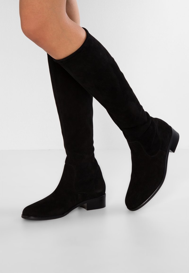 Bottes montantes en daim noir avec un bout pointu et un petit talon bloc, présentant une texture lisse et des détails de couture minimalistes.