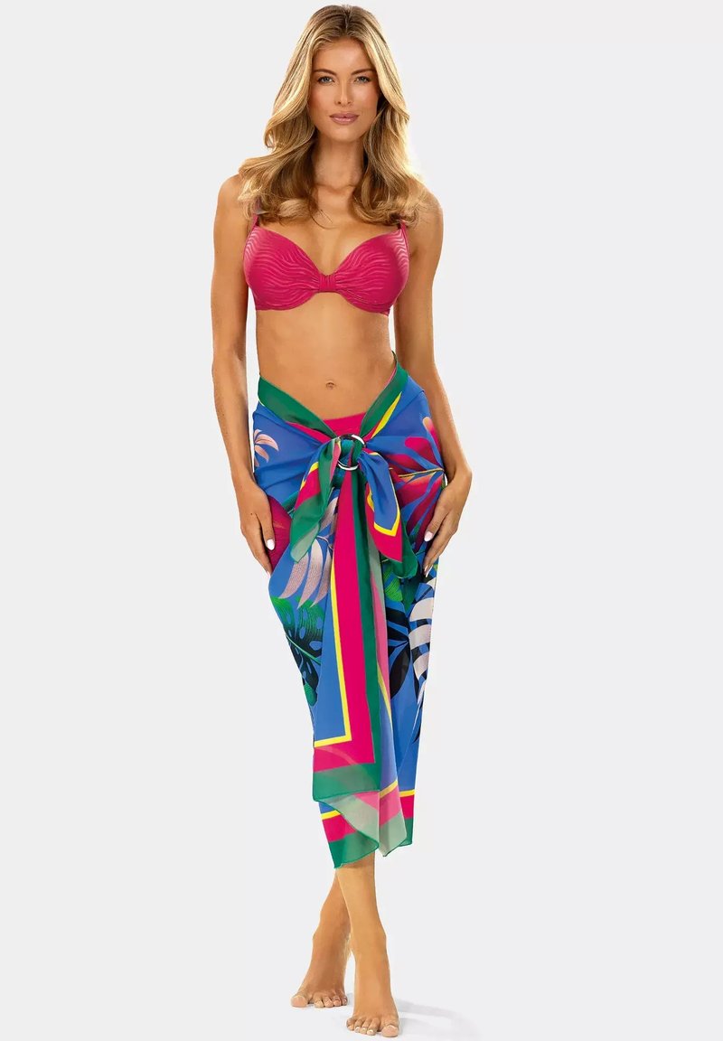 Różowy bikini z teksturą w połączeniu z żywym niebieskim sarongiem w tropikalny wzór z zielonymi i różowymi akcentami, zawiązanym w talii.