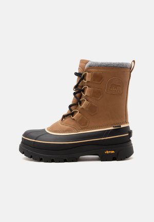 Brauner und schwarzer isolierter Winterstiefel mit Schnürung vorne, Fleecefutter am Kragen, Gummisohle und Sorel-Logo an der Seite.